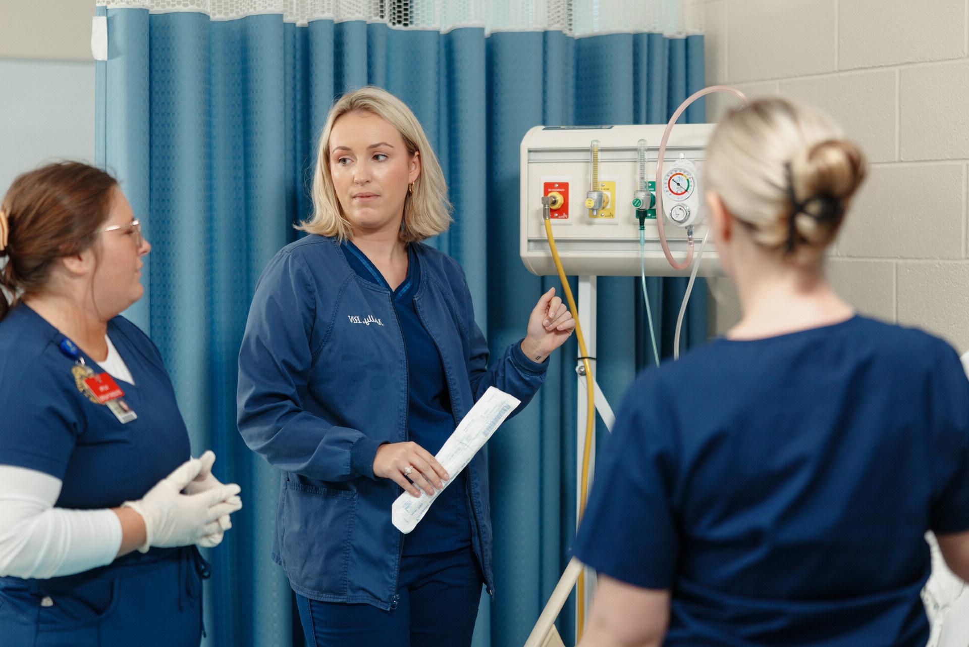 Nursing student putting a mask onto a training dummy